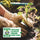 Hand wearing a gardening glove holding a small plant with an Organic certification label.