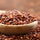 uncooked red quinoa in a wooden spoon